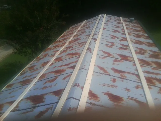 Rusted metal roof panels with new wood purlins before replacement — Storm Damage Roof Repair in Fair Oaks by Roofing Brothers